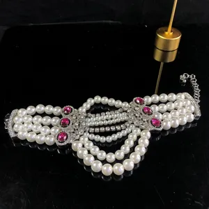 Vista detallada del collar de perlas multicapa con detalles de cristales rosas y pedrería fina.