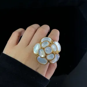 Close-up detail of a gold plated mother of pearl camellia flower ring elegant accessory.