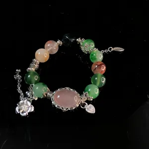 Detailed view of crystal beaded bracelet with metal charms, elegant design jewelry piece.
