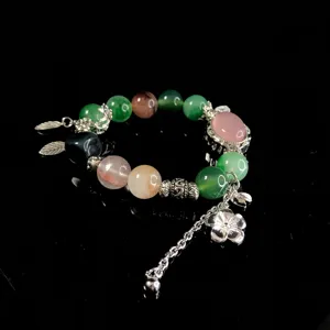 Crystal beaded bracelet detail view showing colorful stones and delicate silver flower charms.