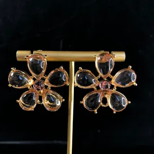 Close-up detail of vintage flower earrings featuring crystal teardrop petals and gold finish.