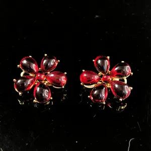 Detailed close-up of vintage red flower resin earrings with gold-tone setting and glossy shine.