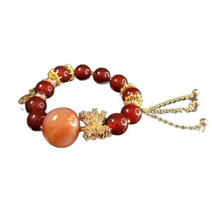 Exquisite red agate crystal beaded bracelet with chic gold metal charms for women's stylish wear.
