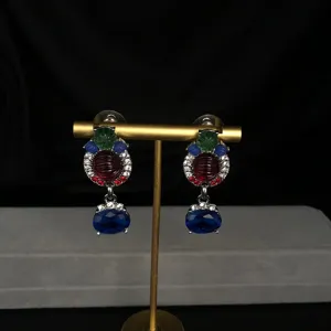 Detailed close-up shot of vintage multi-color rhinestone statement earrings on gold stand.
