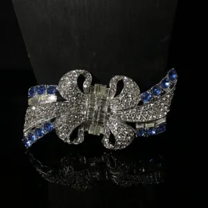 Primo piano dettagliato della spilla a fiocco vintage con strass scintillanti e cristalli blu.
