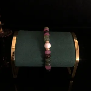 Detailed view of a multi-color tourmaline flat bead bracelet with a central white pearl.