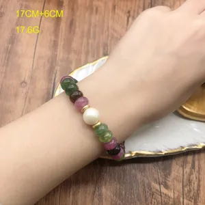 Detail shot of colorful tourmaline and pearl bracelet on hand, showcasing exquisite bead texture.