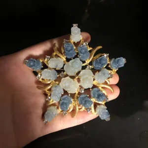 Detailed view of the exquisite star-shaped brooch featuring blue and white rose motifs.