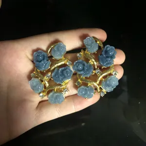 Exquisite blue rose floral drop earrings featuring gold branch design with sparkling crystals.