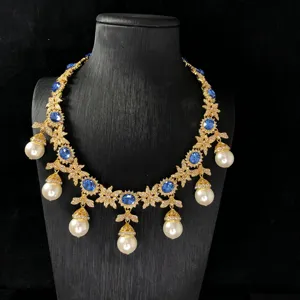 Exquisite vintage blue sapphire rhinestone necklace detail featuring elegant hanging pearl drops.