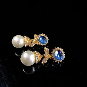 Vintage style blue gemstone and pearl dangle earrings detail shot, elegant jewelry.
