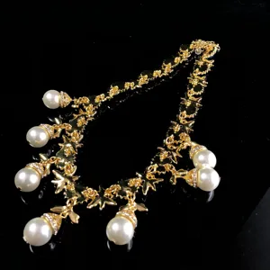 Vintage gold-toned pearl pendant necklace with intricate ornate links and dangling pearls.