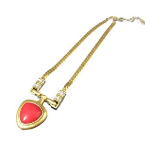 Vintage gold-toned chunky chain necklace with striking red triangular pendant and rhinestone details.