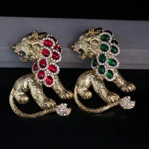 Vintage style gold-toned lion brooch set featuring red and green gemstone crystal accents.
