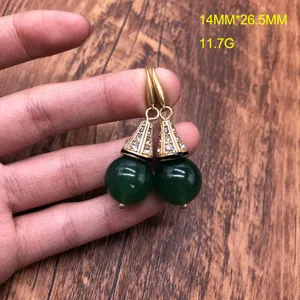 Detailed close-up of vintage green beaded drop earrings with ornate rhinestone cone caps.