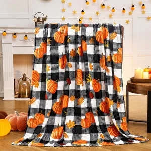 Accogliente coperta flanella autunnale quadri zucca, dettaglio biancheria morbida, arredo casa.