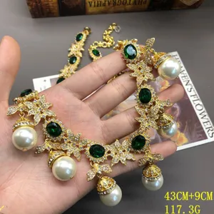 Vintage gold necklace with green gemstone and pearl pendants, elegant detail jewelry view.