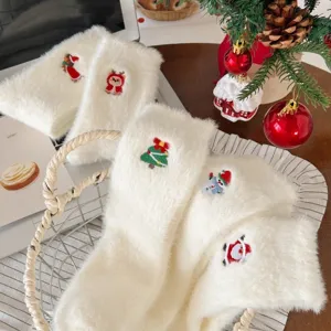 Chaussettes en peluche blanches et douillettes avec de belles broderies de Noël pour l'hiver.