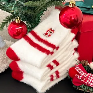 Detalle de calcetines navideños peludos, calcetines de invierno cálidos a rayas rojas.