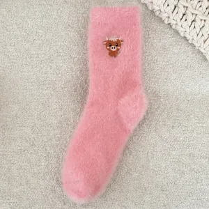 Gros plan détaillé de chaussettes moelleuses roses douillettes avec une jolie vache.