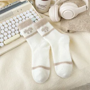 Cozy fluffy women socks detail, white plush knit with cute bow and stripe pattern.