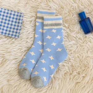 Chaussettes mi-hautes d'hiver pour femmes en peluche avec motif d'étoiles bleues et blanches.