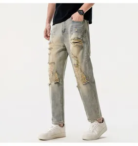 Close-up detail of men's vintage wash distressed cropped straight leg denim jeans.