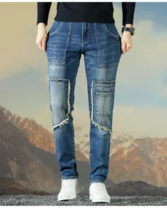 Vista detallada de jeans de mezclilla elástica azul para hombre con bolsillos y flecos.