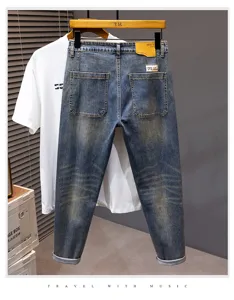 Jeans blu lavaggio vintage da uomo, stile classico con strappi e risvolto alla moda.