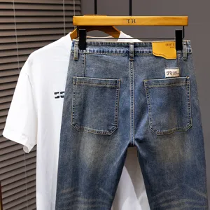 Jeans corti lavaggio vintage da uomo con t-shirt bianca, outfit casual da giorno.