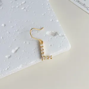 Nahaufnahme des vergoldeten Ohrrings mit einem micro-besetzten Zirkonia-Buchstaben L.