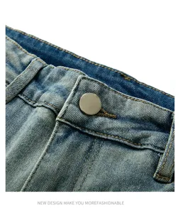 Gros plan sur la taille du jean avec bouton en métal et détails délavés vintage.