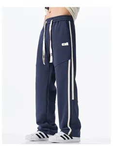 Detailed view of loose fit casual sports sweatpants with white side stripes and drawstring.