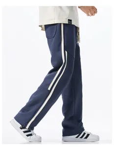 Side view detail of loose straight leg sweatpants with dual side stripes in navy blue.