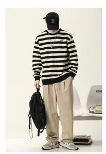 Pull-over rayé noir et blanc à col rond rétro stylé avec un look vintage décontracté.