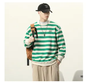 Vue détaillée du sweat-shirt ample à rayures vertes et blanches au style décontracté et moderne.