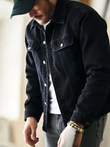 Men's dark denim jacket detail shot, featuring classic lapel collar and metal button front.