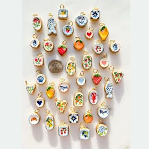 Close-up detail of colorful handmade ceramic fruit and heart charms for DIY necklaces