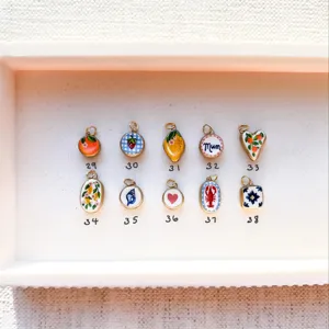 Detailed macro view of ten colorful 18K gold plated enamel charms with various patterns