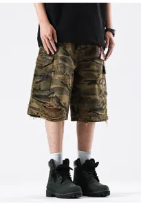 Detail shot of distressed camouflage cargo shorts featuring multi-pockets and raw hem styling.