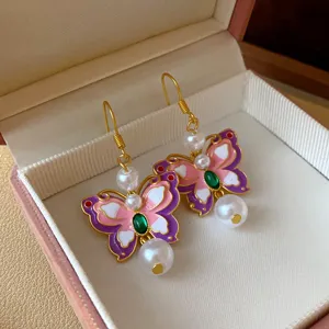 Butterfly drop earrings detail, cute pink and purple enamel design with faux pearl.