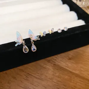 Closeup of gradient enamel butterfly earrings set with sparkling cubic zirconia teardrop drops.