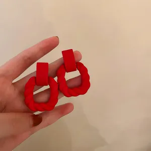 Red matte geometric twisted hoop earrings, minimalist niche design for women daily wear.