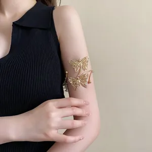 Bracciale da braccio aperto a farfalla in metallo dorato da donna, dettaglio gioiello chic.