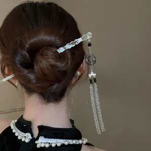 Vue détaillée de l'épingle à cheveux exquise de style chinois avec glands, accessoire élégant.