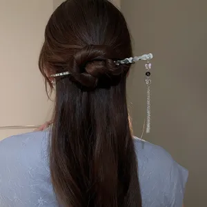 Vue détaillée d'un bâton de cheveux élégant avec de délicaux pampilles de papillon.