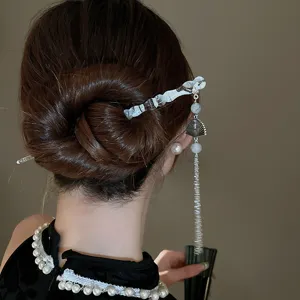 Gros plan détaillé de la magnifique épingle à cheveux de style chinois avec pompon.