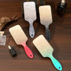 Detail shot of ABS hair brush with shimmering gradient design, smooth cushion paddle style.