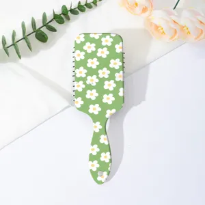 Detailed view of the cute green daisy floral air cushion hair comb, showing fine pattern texture.