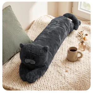 Long grey cat plush pillow detail shot showing soft fluffy fabric, cozy bedroom setup on blanket.